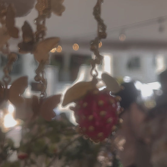 Aretes de fresas deliciosas en un hermoso jardín por mariposas